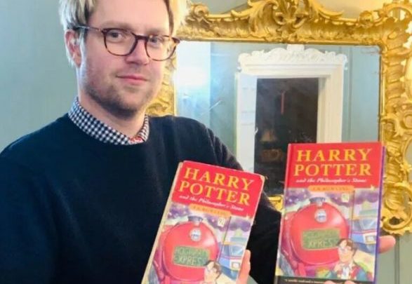 Un empleado de Hansons Auctioneers posa con los dos ejemplares de Harry Potter subastados.